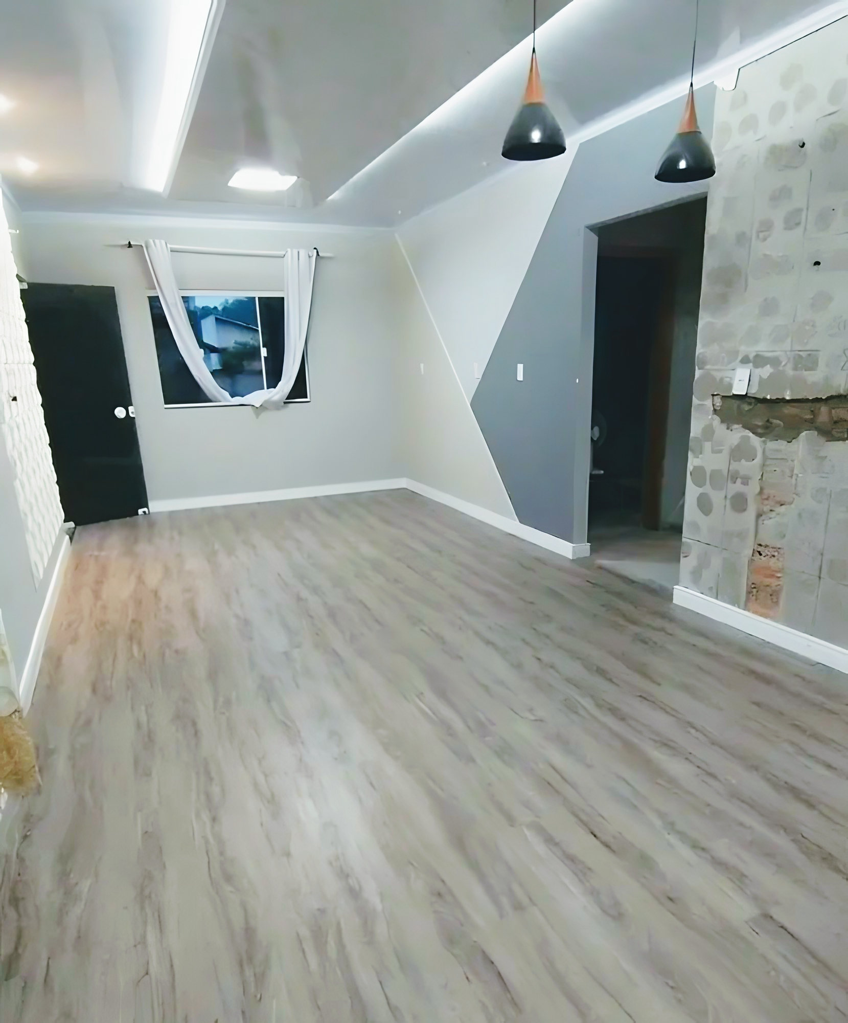 Sala ampla com piso vinílico cinza amadeirado