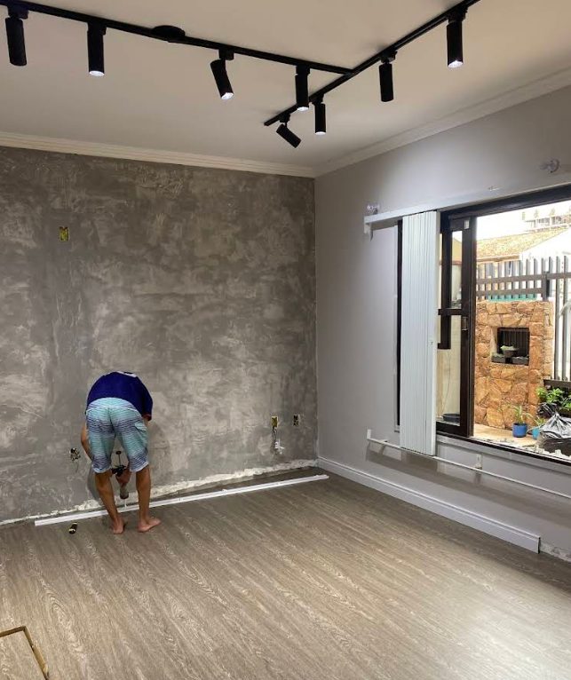 Instalação de rodapé em sala com piso cinza